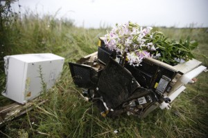 Flowers lie on debris from a Malaysian Airlines Boeing 777 plane which was downed on Thursday near the village of Rozsypne